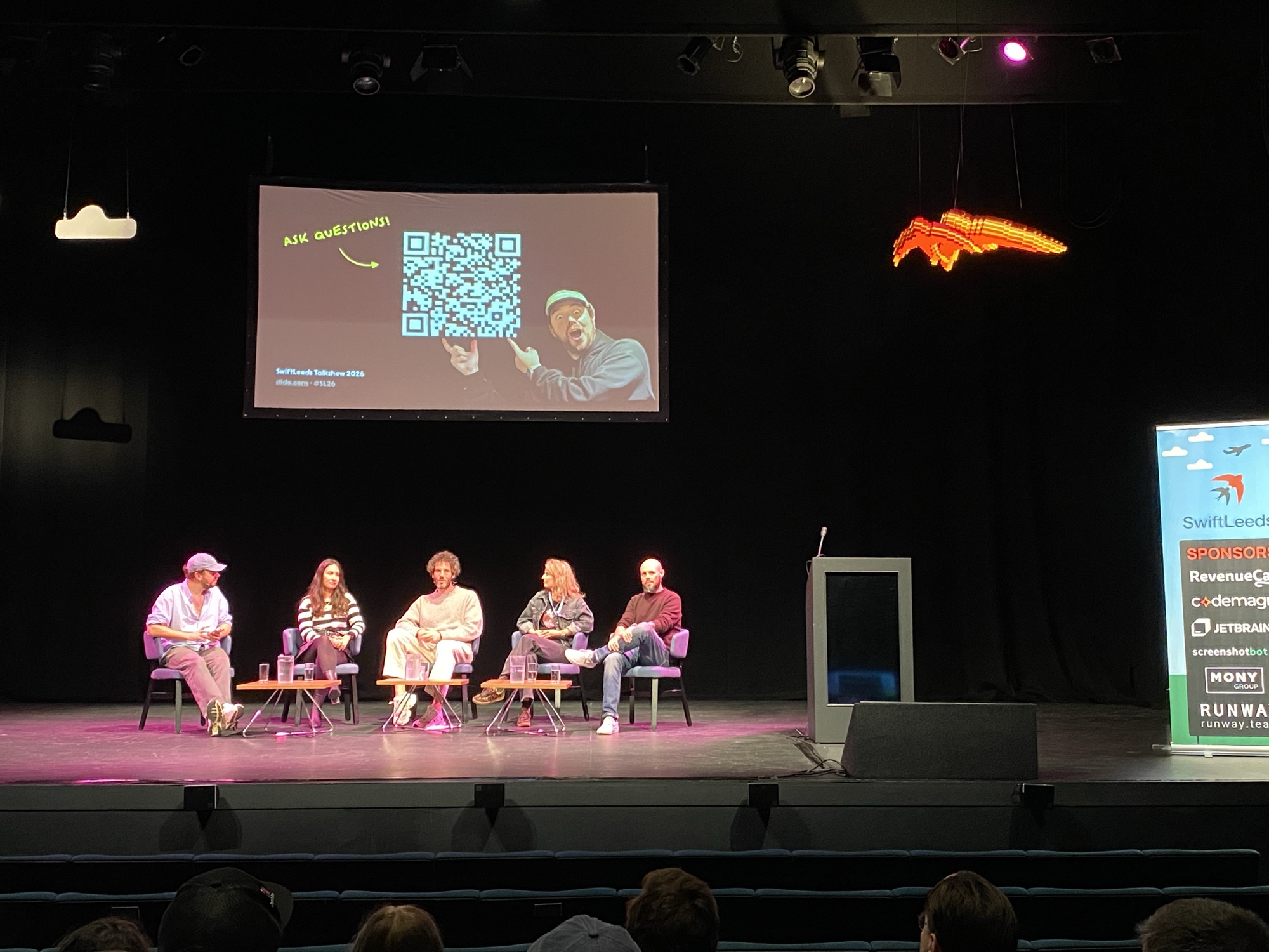 Talkshow host Hidde and four panelists seated on stage during the SwiftLeeds Talkshow 2026